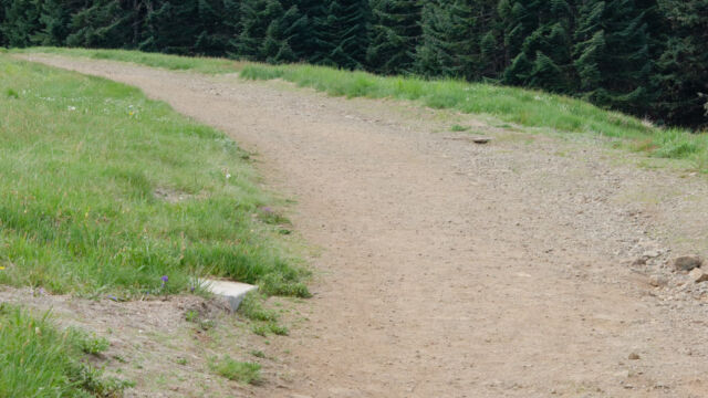 Dirt road leading up from the parking lot towards the peak, and the meadow trail Dirt road leading up from the parking lot towards the peak, and the meadow trail