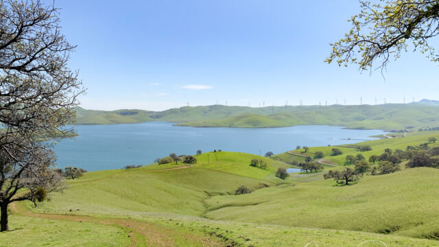 View of the reservoir, showing the trail, and the wind farm in the distance West Loop Trail. View of the reservoir, showing the trail, and the wind farm in the distance